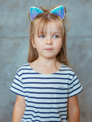 caucasian adorable cute sweet little girl with long blonde hair in striped t-shirt and cat's ears