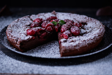 Chocolate clafouti with cherry on a wooden table. French delicious dessert.