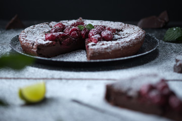 Chocolate clafouti with cherry on a wooden table. French delicious dessert.
