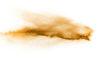Abstract orange powder explosion on white background. Freeze motion of orange dust particles splash.