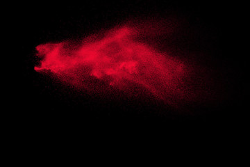 Red powder explosion on black background. Freeze motion of Red dust particles splash.