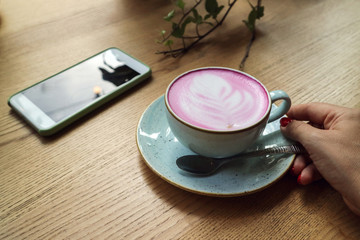 Cup of pink cappuccino in blue cup