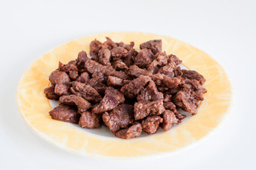Close-up shoot of tasty meat on small plate with white background