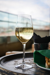 Glass with cold white wine on wooden table