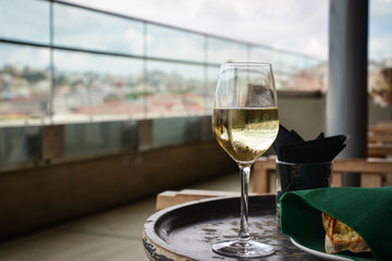 Glass with cold white wine on wooden table