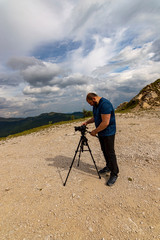 Photographer traveler taking pictures of landscape in the mountains.