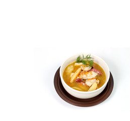 a bowl of brown soup on a white background