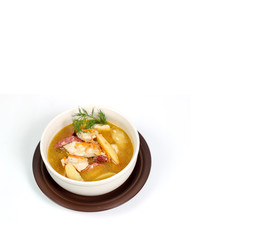 a bowl of brown soup on a white background