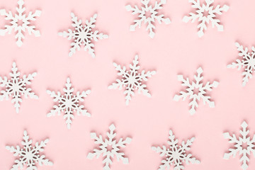 Christmas background. White snow decorations on a pink background.