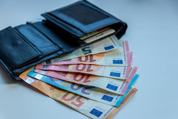 EURO-Geldscheine stecken in einem schwarzen Portemonnaie und stehen für Bargeld, Cash, Reichtum, passives Einkommen und Bezahlung im Finanzsektor