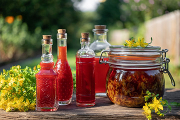 Bottles of oil made from St. John's wort flowers, outdoors