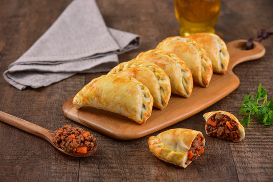 Meat roasted empanas on wooden background