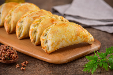 Meat roasted empanas on wooden background