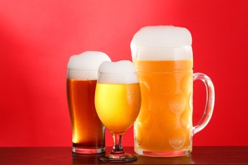 Golden beer in glass with foam, alcohol beverage,  lager background.