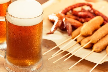 Beer glass alcohol drink with food sausage,  pub board.