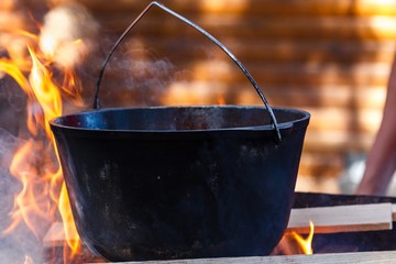 Bowler cooking food bonfire cauldron,  wood.