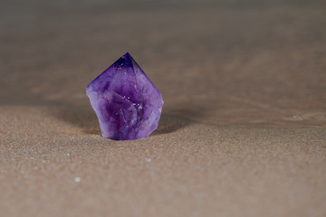 Large Amethyst Phantom  Point from Brazil on wet sand on the beach at sunrise.
