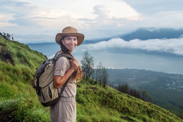 Woman enjoying sunrise from a top of mountain Batur, Bali, Indonesia.