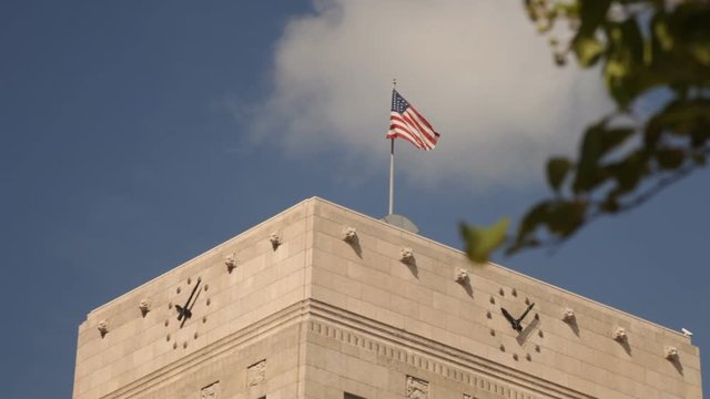The American flag a top a city courthouse waves gently in the breeze.