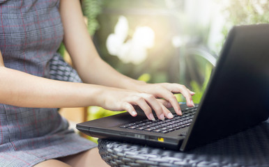 Closeup of hands young asian woman using laptop working in outdoor garden with nature background