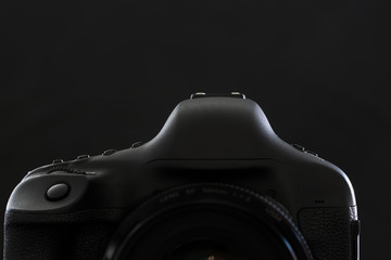 Professional modern DSLR camera low key stock photo/image - Modern DSLR camera with a very wide aperture lens on with highlighted edges against black background