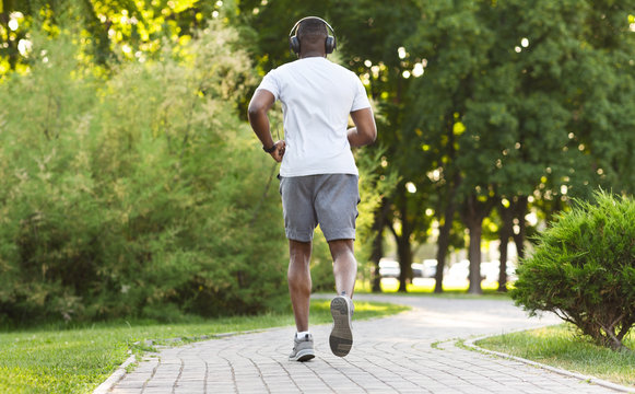 Athletic African American Man Running Along The Park Trail