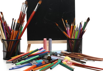 Painting, art supplies on desk, blackboard background