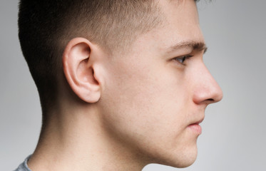 Serious millennial caucasian guy side view portrait