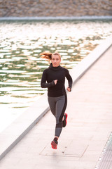 Beautiful young sportive woman jogging in the park