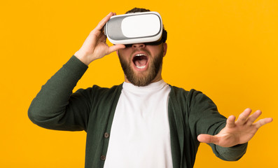 Naklejka premium Excited man having good time with vr glasses on