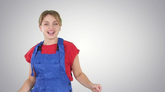 Woman in construction helmet dancing on gradient background.