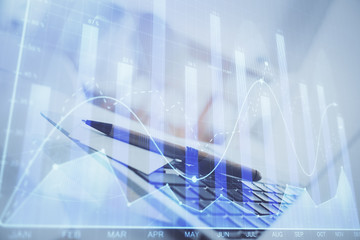 Forex graph hologram on table with computer background. Multi exposure. Concept of financial markets.