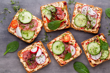 Sandwiches with cream cheese, vegetables and salami.