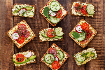 Sandwiches with cream cheese, vegetables and salami.