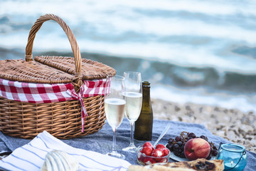 Summer beach  romantic picnic at sunset. Seaside light evening picnic  with fresh fruit and tray of...