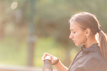 Happy sportive woman drinking water during fitness exercises
