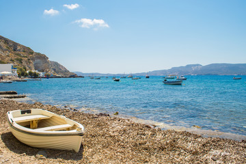 Fototapeta na wymiar Beach with a fishing boat at Klima village in Milos, Greece