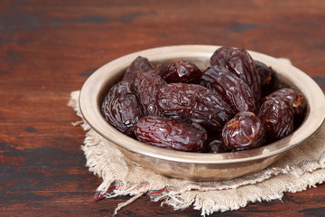 Fresh Medjool Dates in a bowl  on wooden background