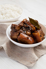 Homemade Filipino Adobo Pork with rice on a white wooden background, side view. Close-up.