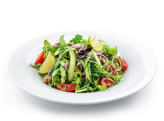 Green salad with arugula, lettuce, tomatoes, avocado, lime, tuna and olives in plate on isolated...