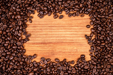 A coffee beans over wooden table top background.