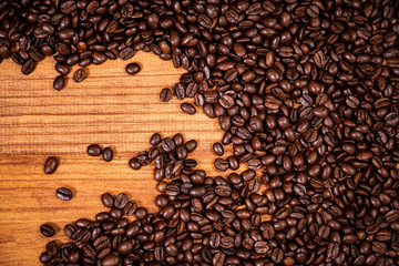 A coffee beans over wooden table top background.