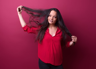young girl removes her hair in front of a red background