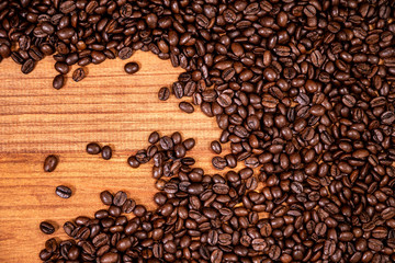 A coffee beans over wooden table top background.