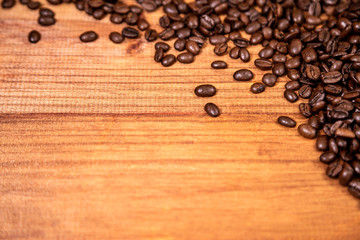 A coffee beans over wooden table top background.