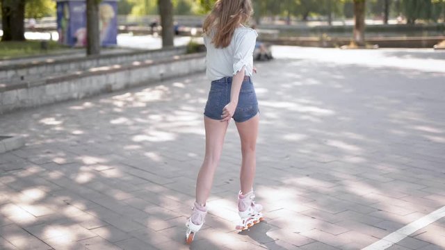Girl playing rollerblades alone. Camera follow from behind
