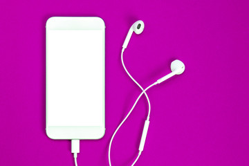 Fototapeta na wymiar White smartphone on the purple background with headphones. View from above.