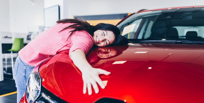 Happy Beautiful Young Woman Buying A New Car At The Car Showroom.