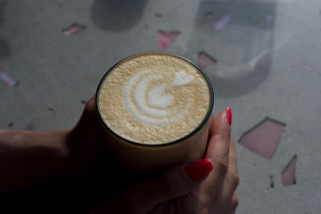 Fototapeta premium Cup of latte at woman hands