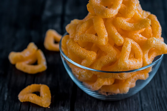 Crispy cornmeal snacks with cheese flavor in a brown bowl.